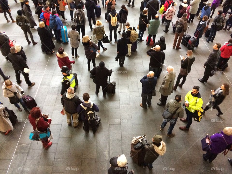 Looking down on the crowded concourse of a busy railway station as. Roads of rail commuters and passengers wait for their train at Kings Cross in London.