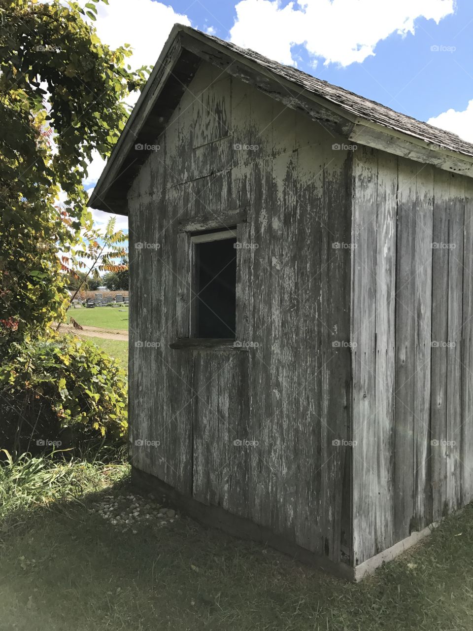 Backside of an old weathered shed in a cemetery 