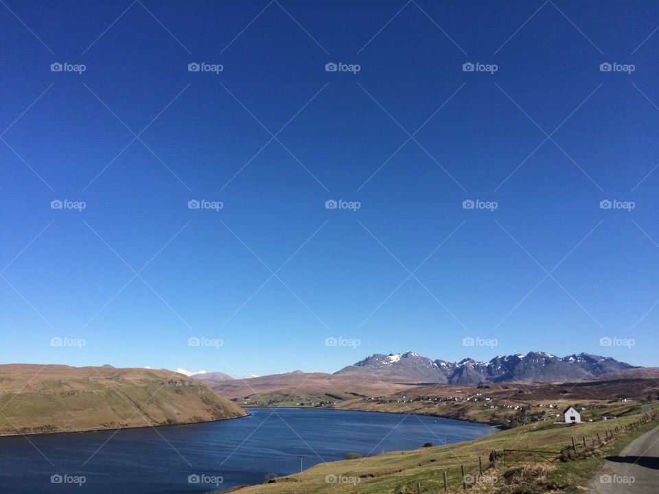 The Black Cuillin Mountains on the Isle of Skye - During summer the beautiful Cuillin mountains watch over the village of Carbost on the Island of Skye in North-West Scotland. A touch of on the higher peaks hints at the temperature near the summits.