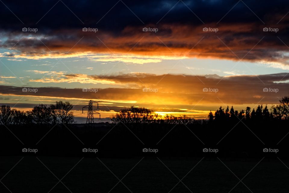 Dramatic sky and silhouette of trees at sunset