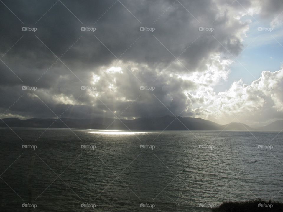 Sun rays on water. sun shining through the clouds