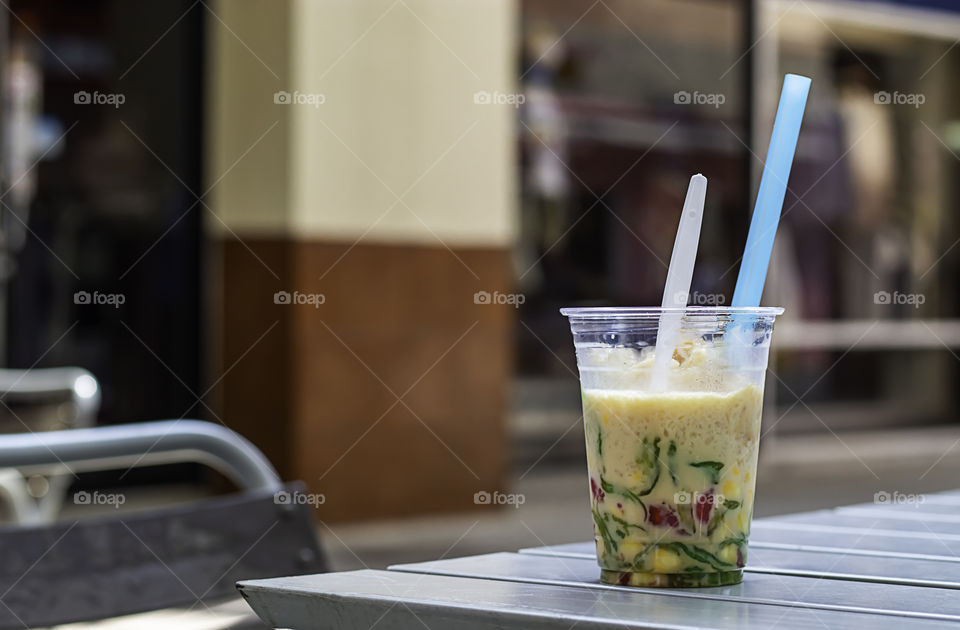 Glass of sweet candy Thailand 
with ice and coconut milk on table