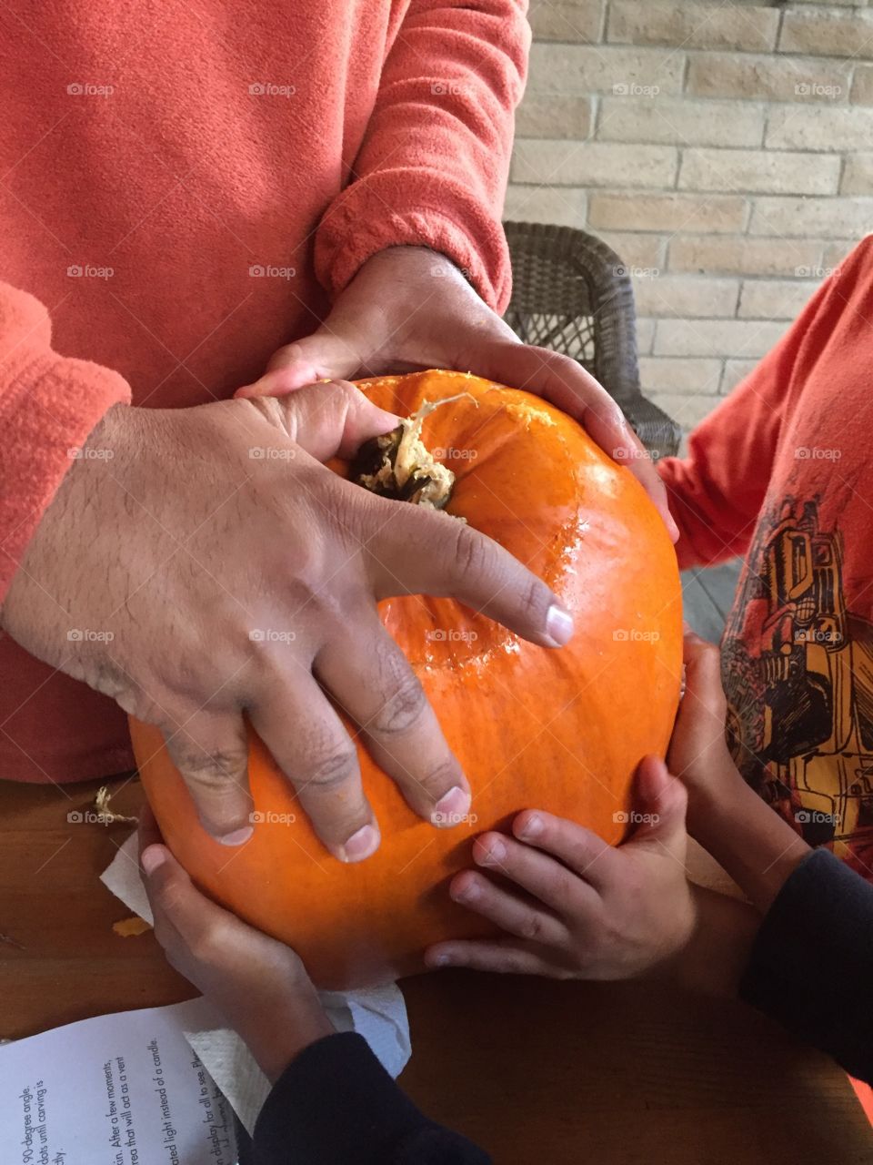 Kids and adults carving pumpkin for Halloween 