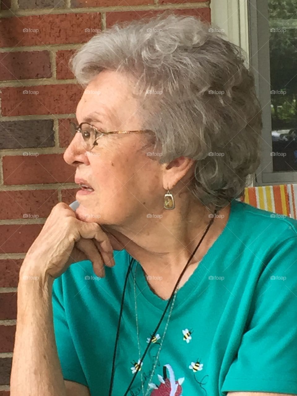 Senior woman in eyeglasses against wall