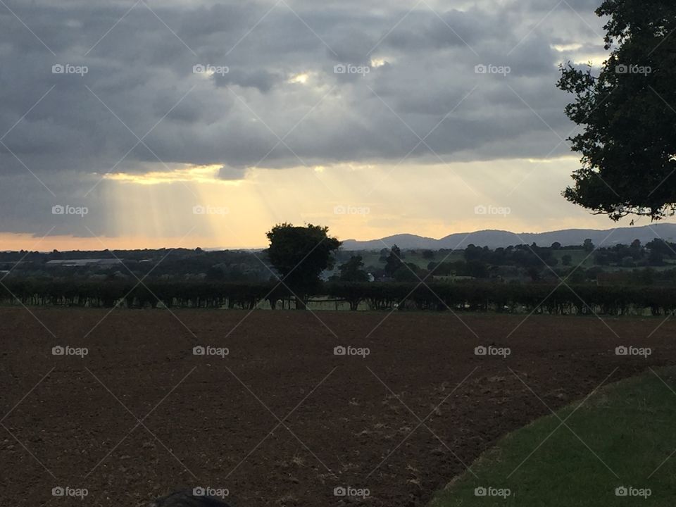 Sun bursting through clouds over Malvern Hills in Worcestershire 