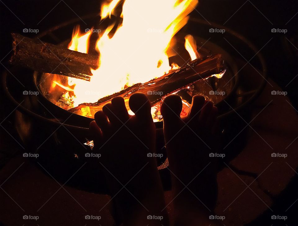 Warming Up The Toes. Warming up the toes by the campfire. 