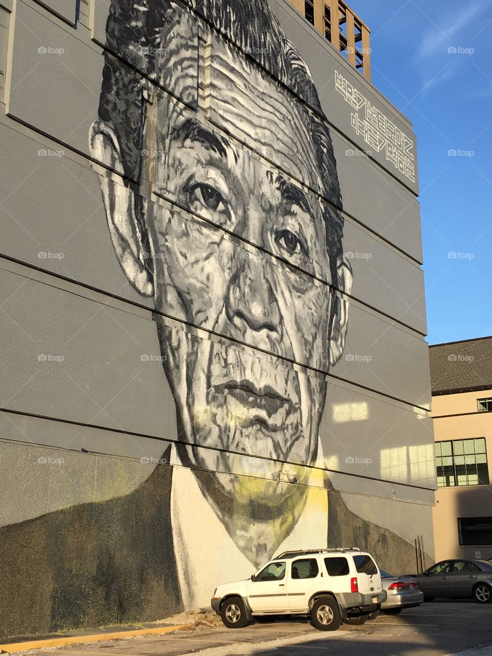 A Painting Of A Korean Man Up On A Giant Wall In The City.