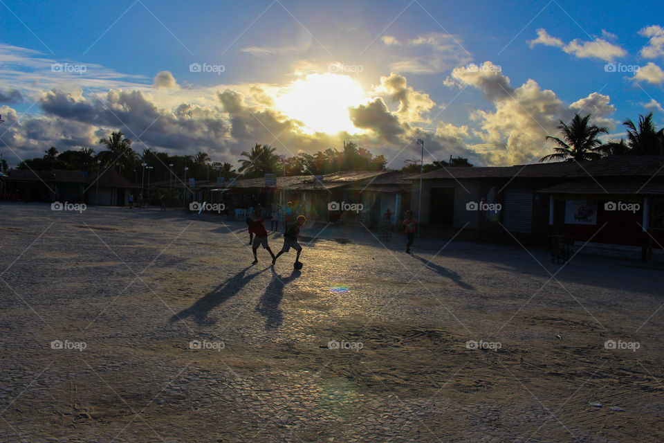 Urban photo of boys playing ball in a fishing village in Brazil