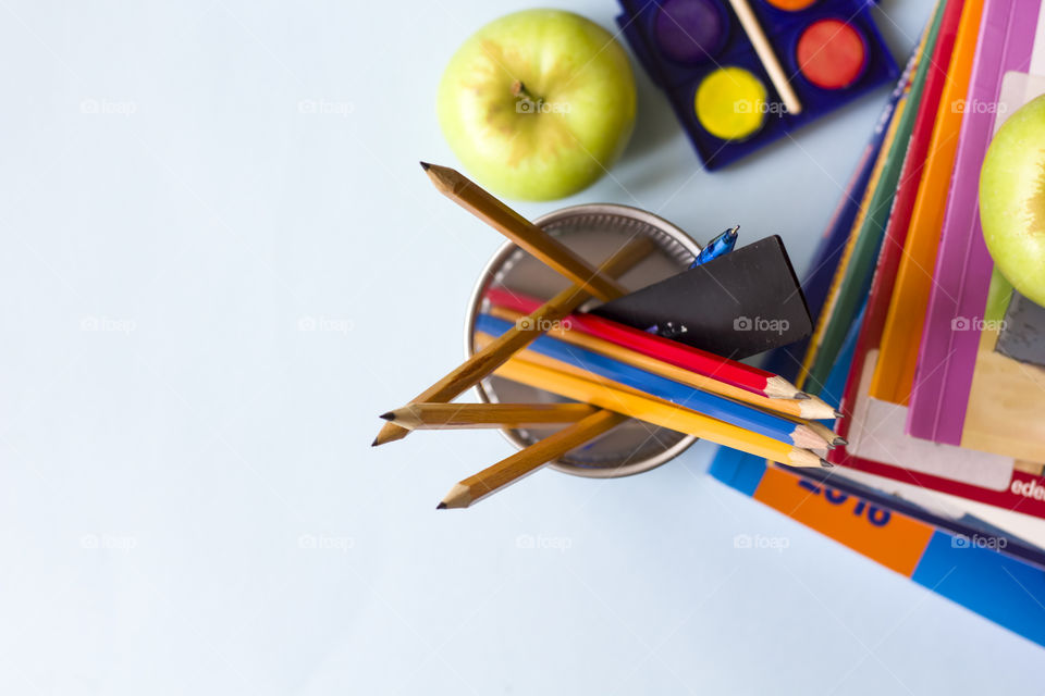 pencils books and apple flat lay