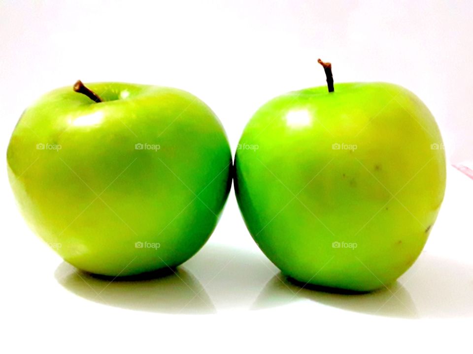 two green apples on a white background