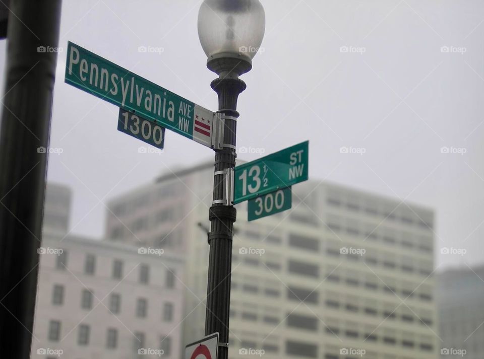 A lamp post and street signs, Pennsylvania and 13 1/2 mark the corner in downtown Washington DC. 