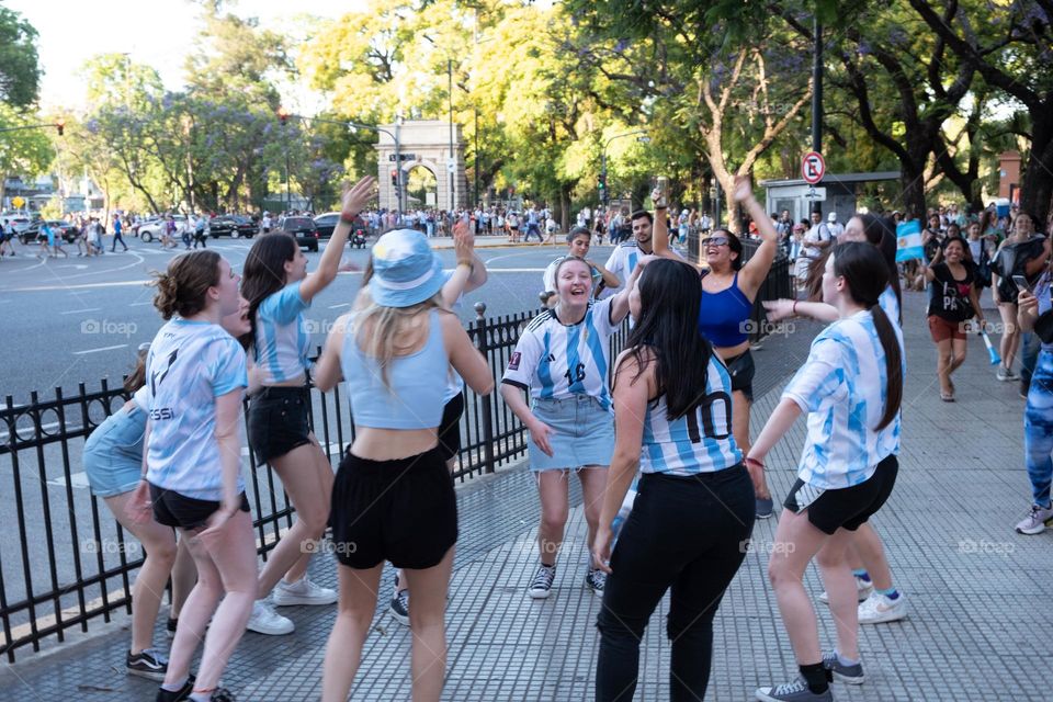 Buenos-Aires - 18.12.2022: Football fans of national team of Argentina in t-shirts on national team celebrating victory on the streets