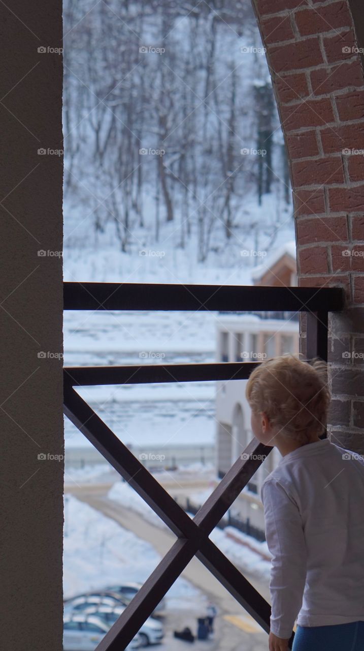 Kid exploring weather from the window 