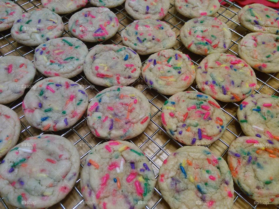 FunFetti Sugar Cookies. Rainbow sprinkle sugar cookies. homemade cookies on a cooking rack, made from scratch.