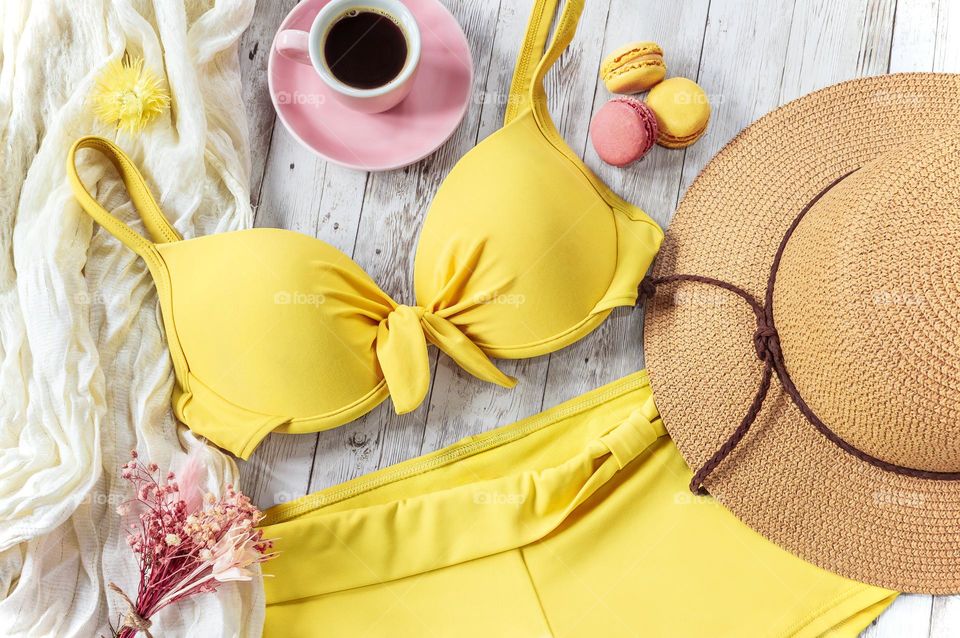 Yellow and pink, summer themed flat lay, with bikini, hat & coffee