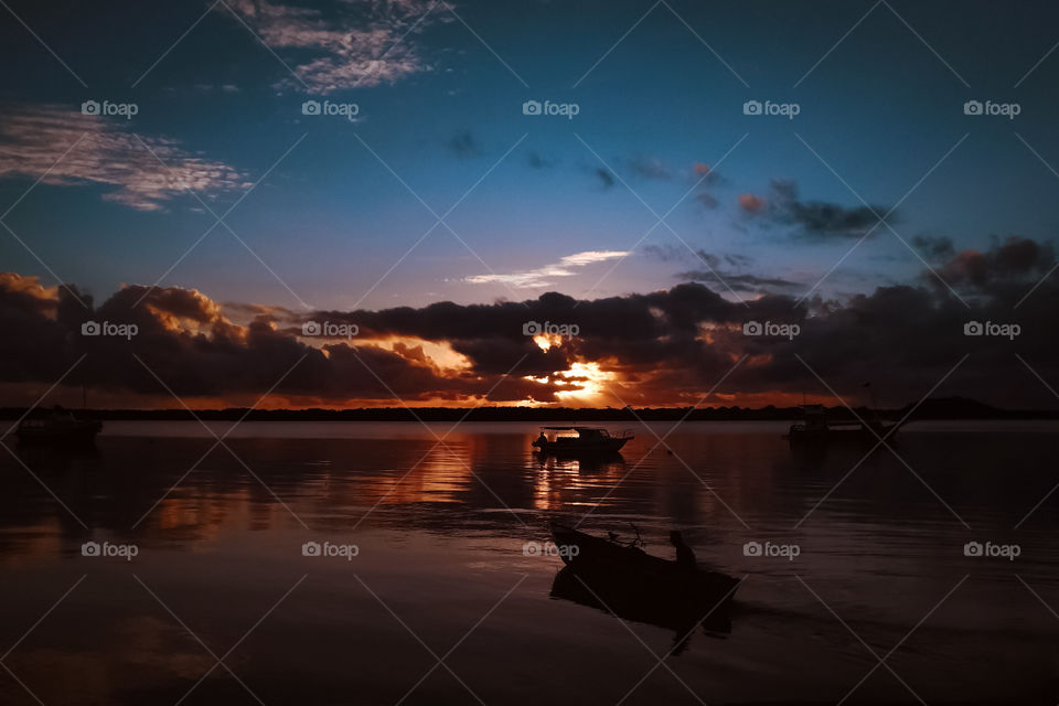 Beautiful Sunrise at Cardoso Island, Brazil / Brasil. Fishing Boats at sea, orange and blue contrast, sunny.