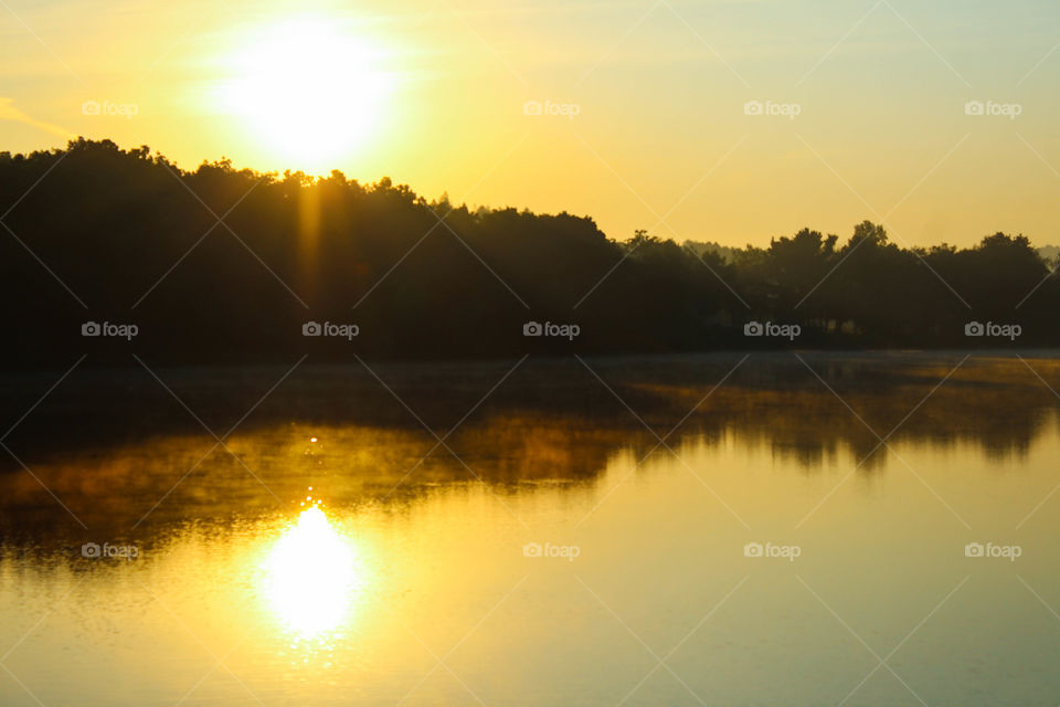 Fog burns off the lake at sunrise