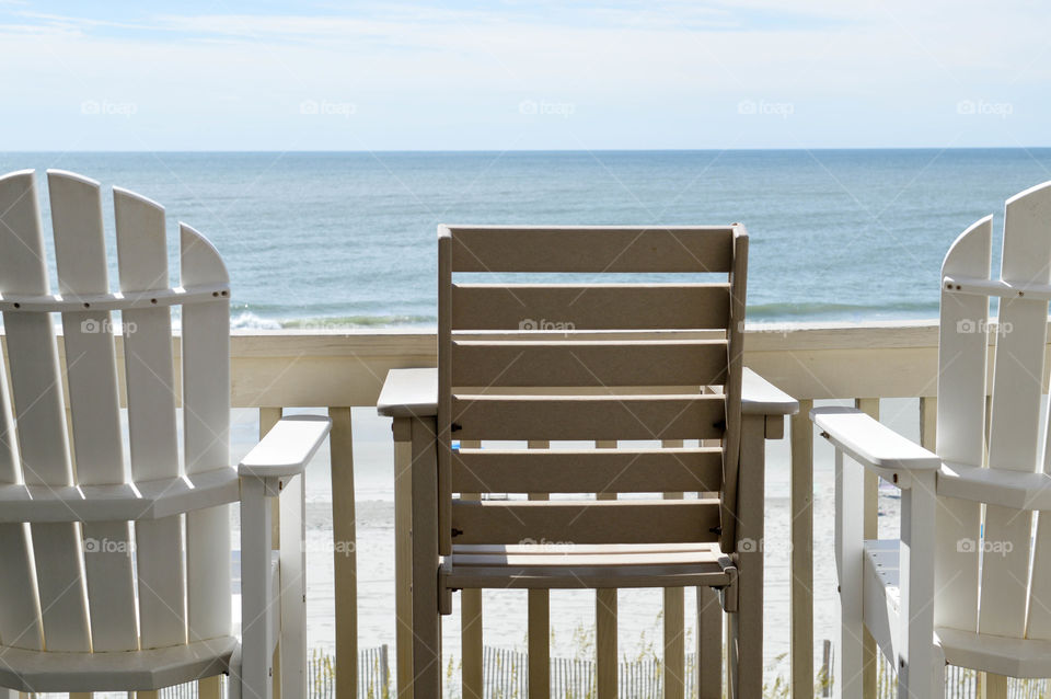 View of empty chairs on a balcony overlooking the ocean