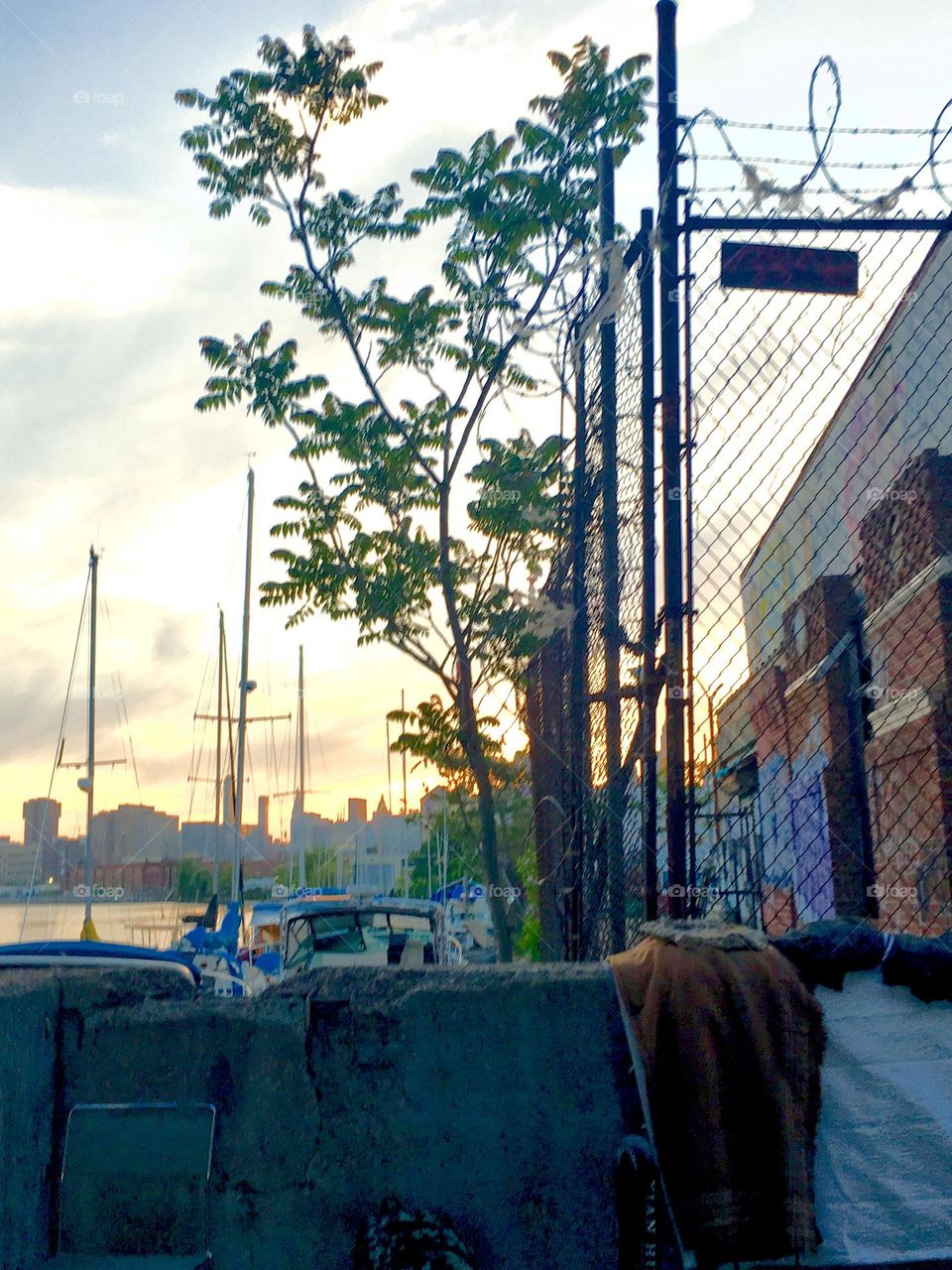 The waters of the East River at Newtown Creek in Long Island City, Queens, NY with sailboats in the twilight hour after sunset is a beautiful motif for photography. 2019. Hypnotic Productions