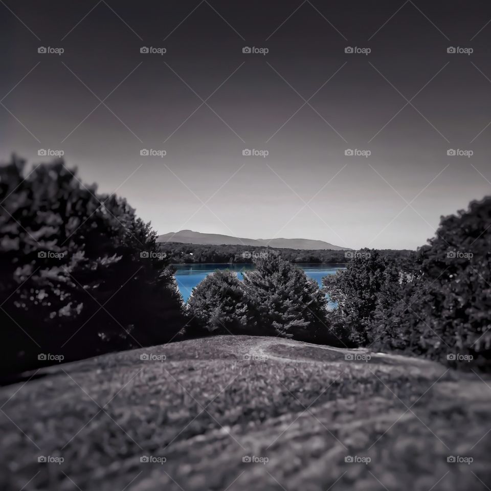 Black and white with color. A warm black and white focus shot of the Hudson River in New York with blue waters. 