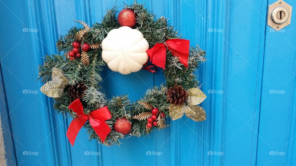 Christmas wreath on blue door with white knob