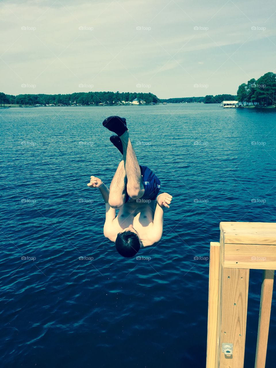 Summer lake jumping teenager flip upside down