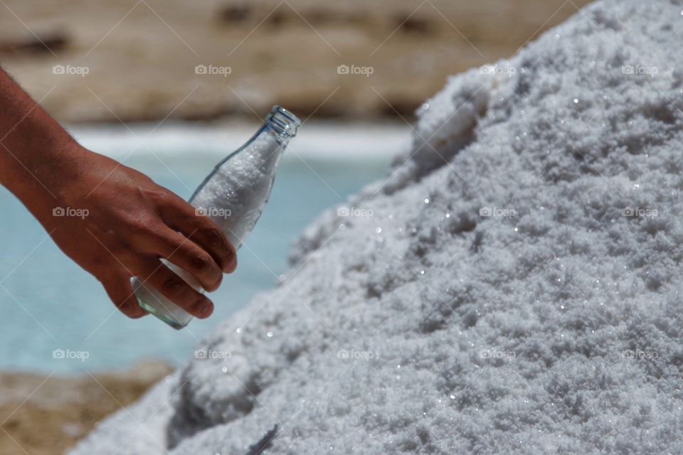 woman filling a glass bottle with salt
