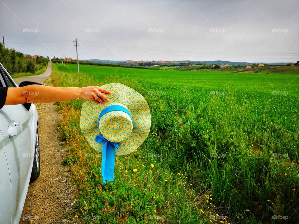 Straw hat outside the car window