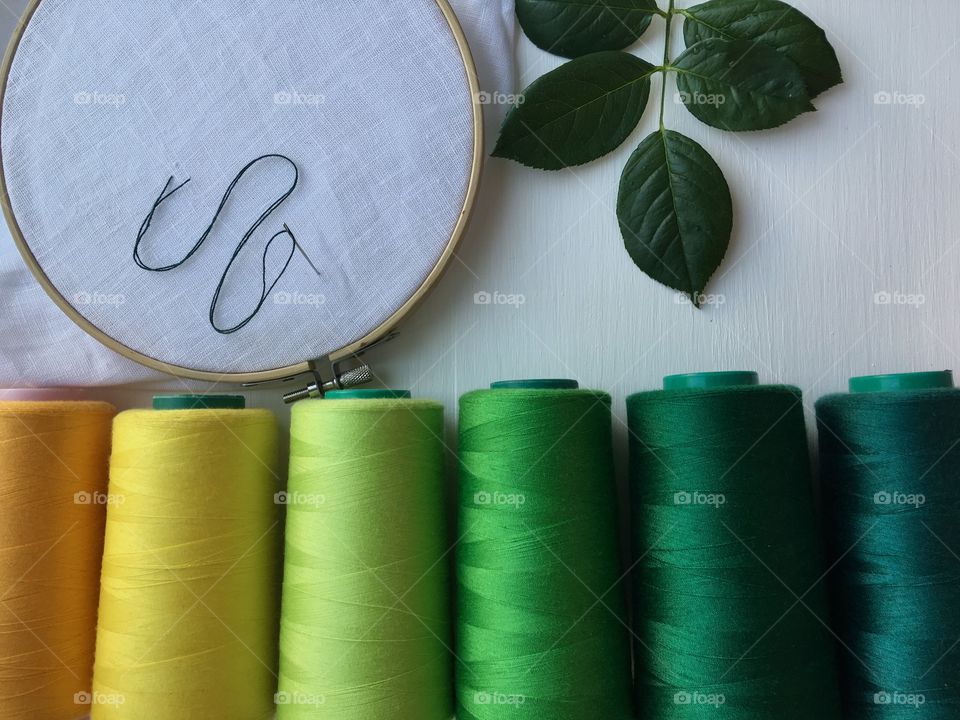 Set the green thread in the bobbin , wooden frame with textile for sewing and embroidery