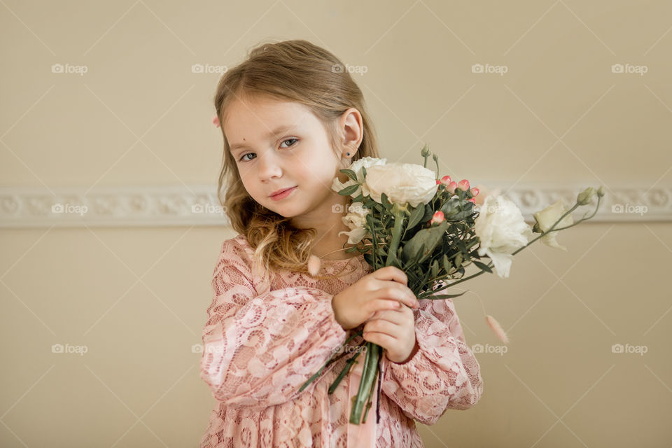 Birthday portrait of a beautiful little girl with bouquet 