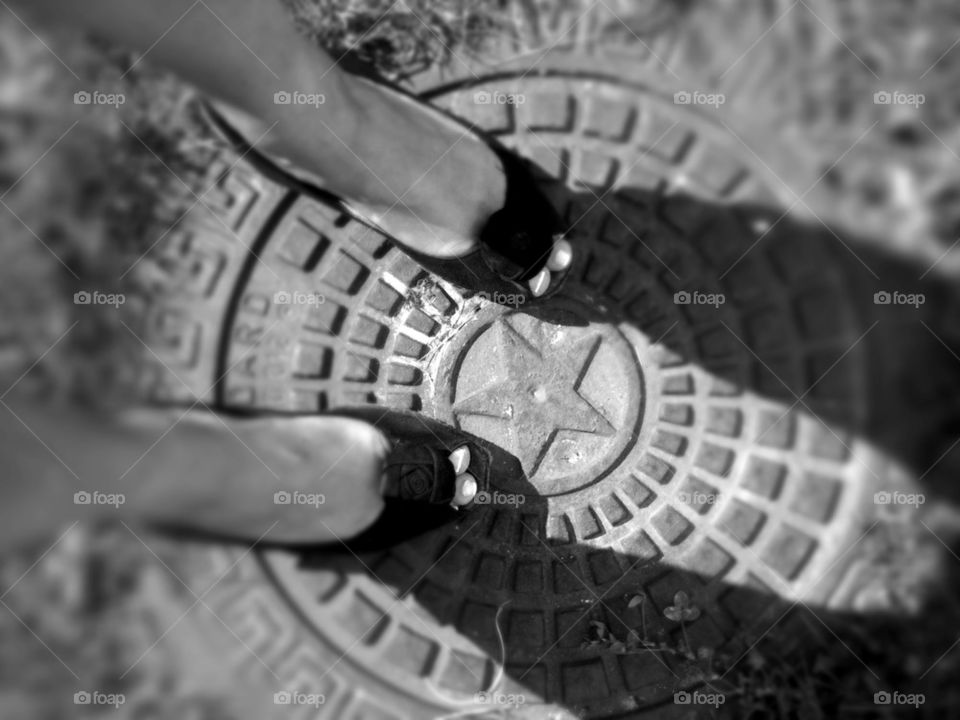 Feet selfie on manhole cover