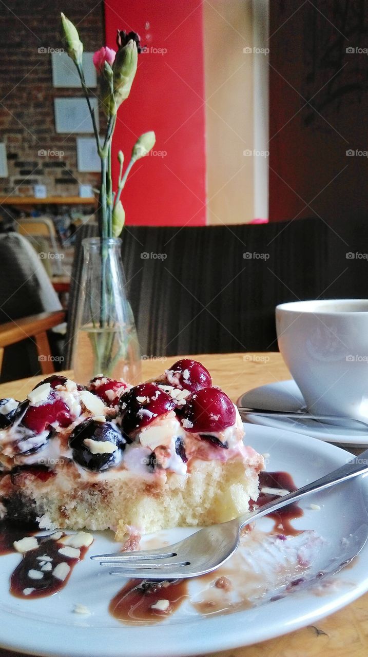 Sponge cake with cherries and coffe in cafe