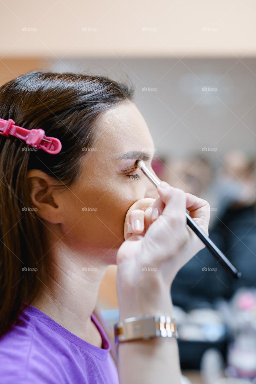 Makeup artist at work.  Applying makeup to a woman.  Professional cosmetics