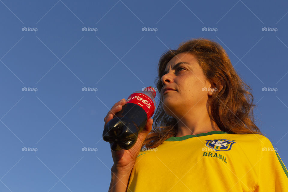 Woman drinking Coca Cola.