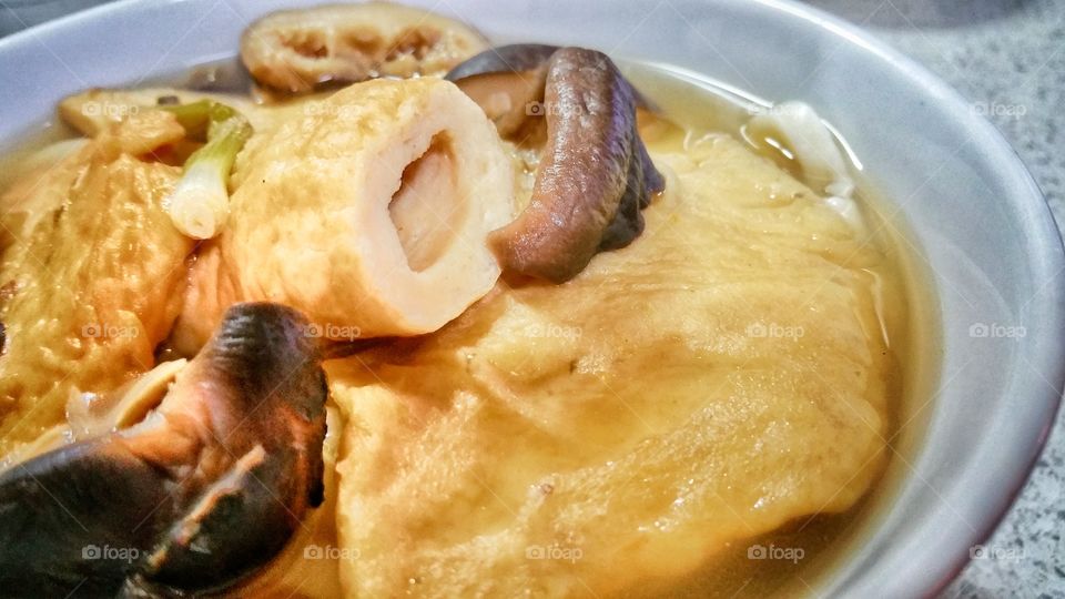 Seafood surimi with shiitake mushrooms udon noodle soup. Seafood surimi is commonly referred to as Oden in Japanese.