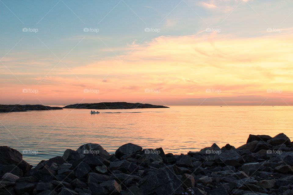 Rocky beach, boat on the sea