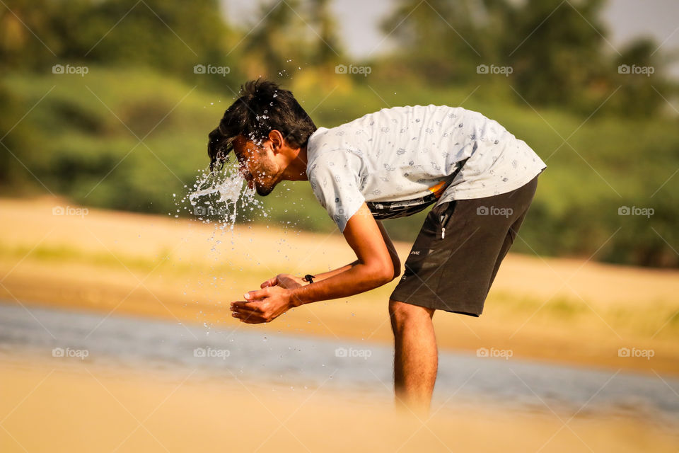 A splash story of a village boy who was washing his face with cool water to manage the hot