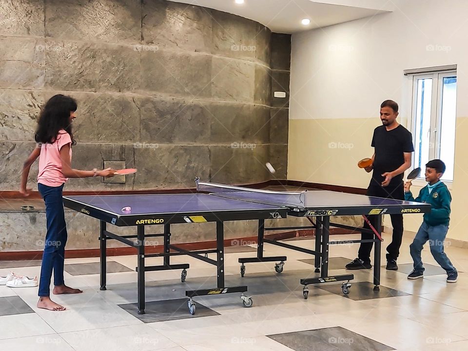 Father and Kids playing table tennis