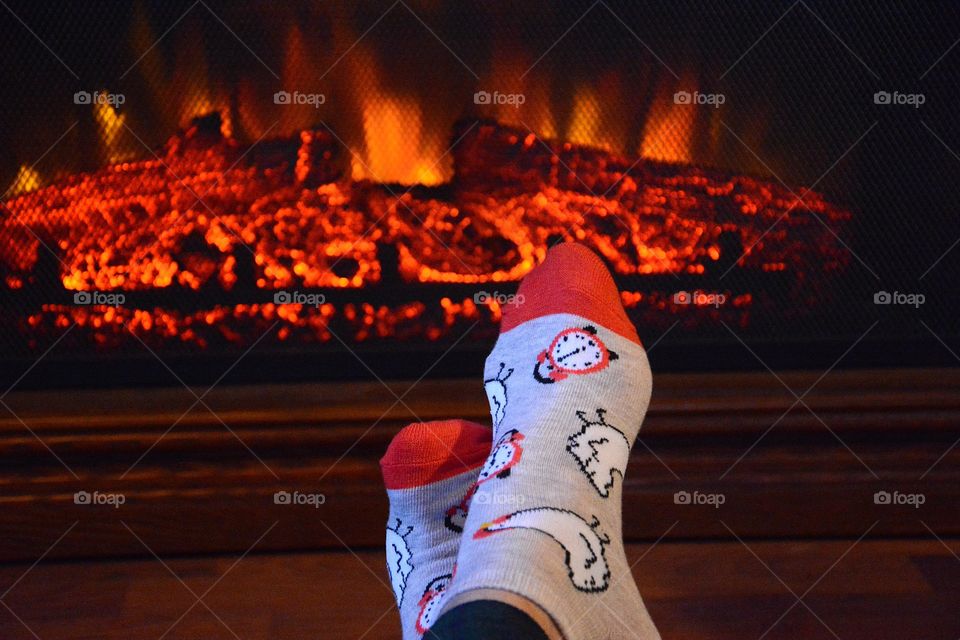 Warm and cozy. warming feet sitting by the fireplace on a winter day.