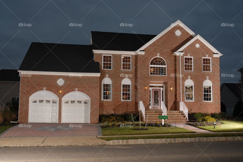 Twilight modern home with twinkling lights inside