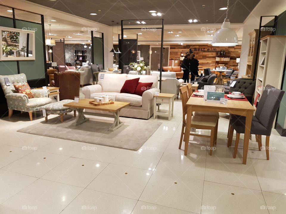 Living space coffee table with rugs and sofas and dining set at Peter Jones Sloane square Chelsea King's road London