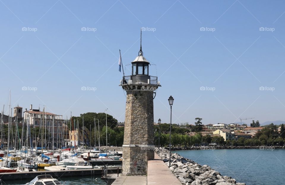 Torre central entre barcos e lago de Garda, em belo dia de sol na cidade de Desenzano del Garda, Italia 