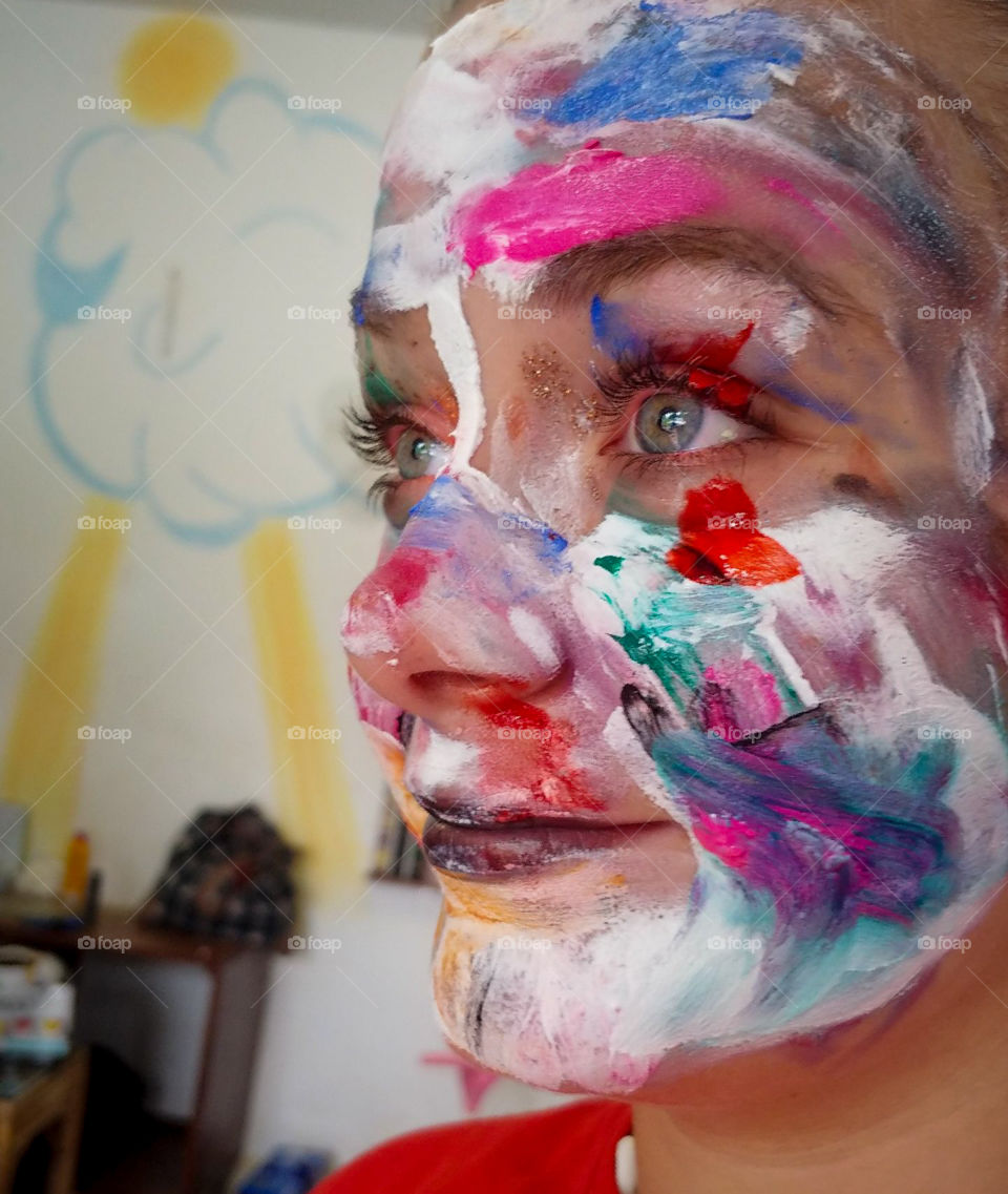 A girls face painted by children.