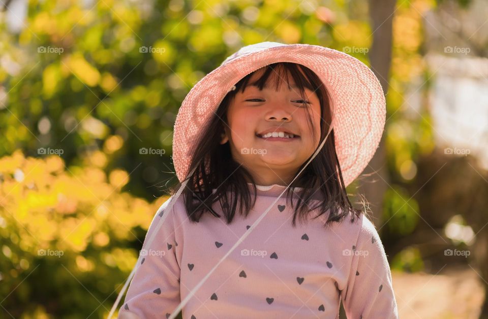 A portrait of a girl with on a warm sunny day, happy in her own world.