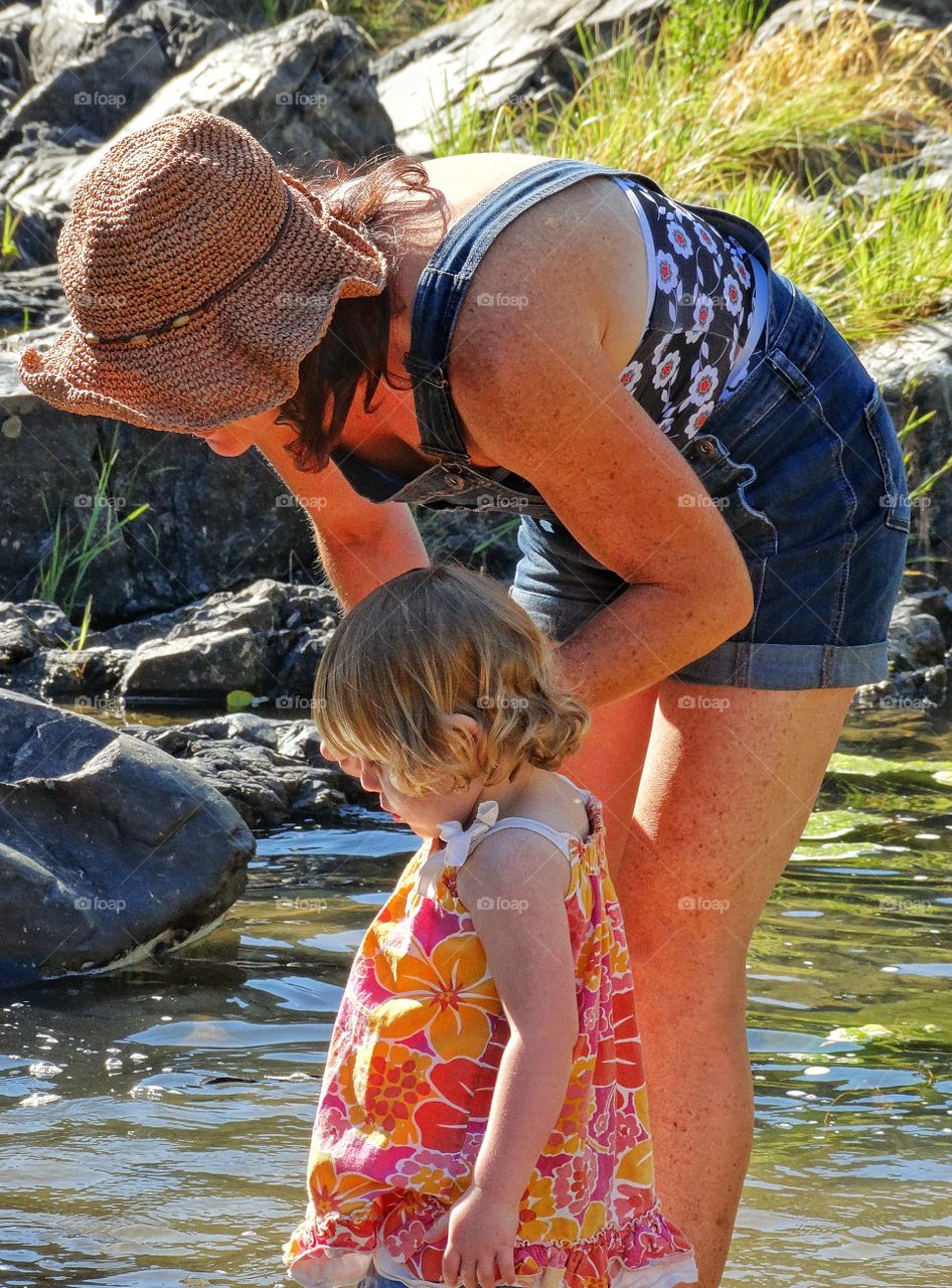 Mother And Daughter. Mother And Toddler Daughter Exploring A Riverbank
