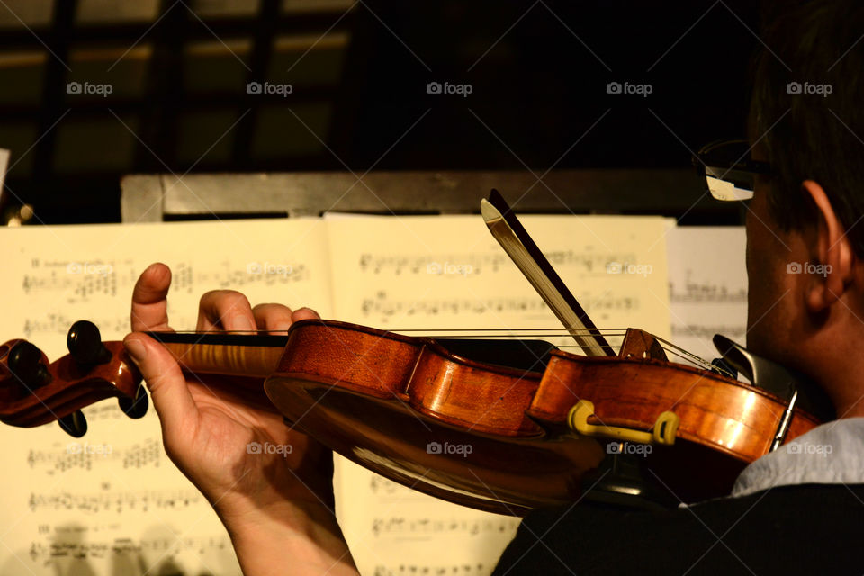 Classical Musician playing the Violin and reading music notes
