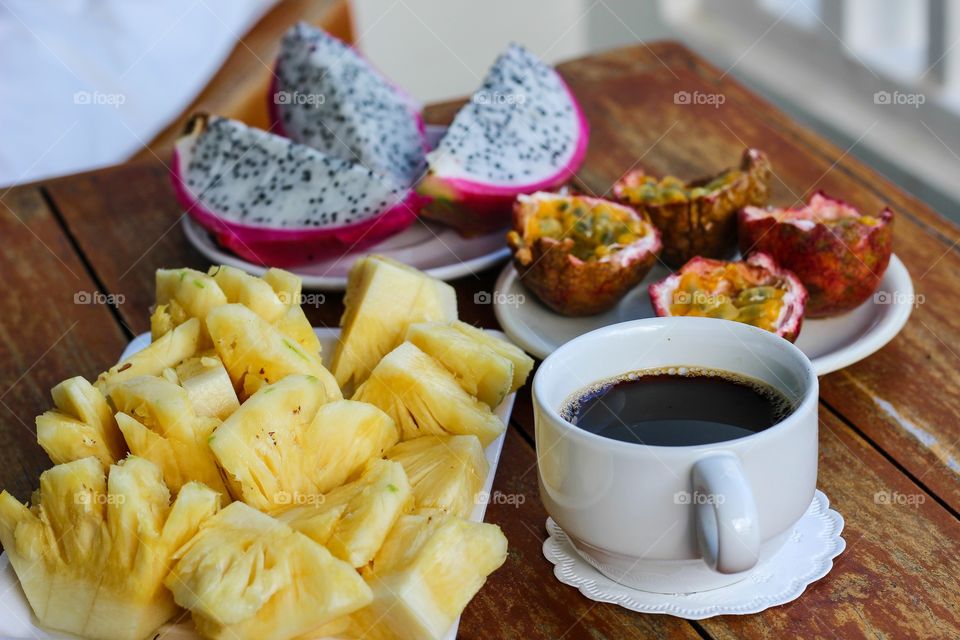 Exotic fruits and a cup of coffee for breakfast