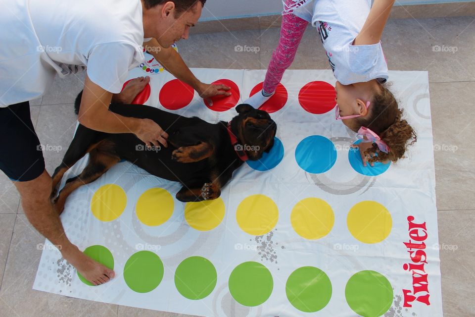 Summertime (Father and daughter trying to play with Twister with Rottweiler)