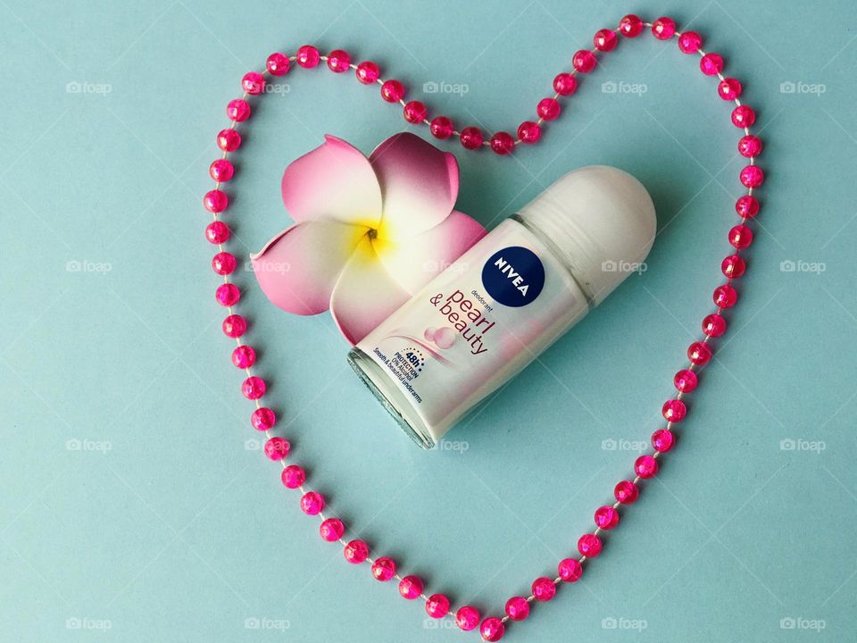 Nivea pearl and beauty roll on deodorant with pink colour pearl chain and pink colour frangipani flower.