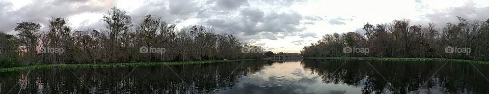 Calm afternoon on the river at dusk; panoramic